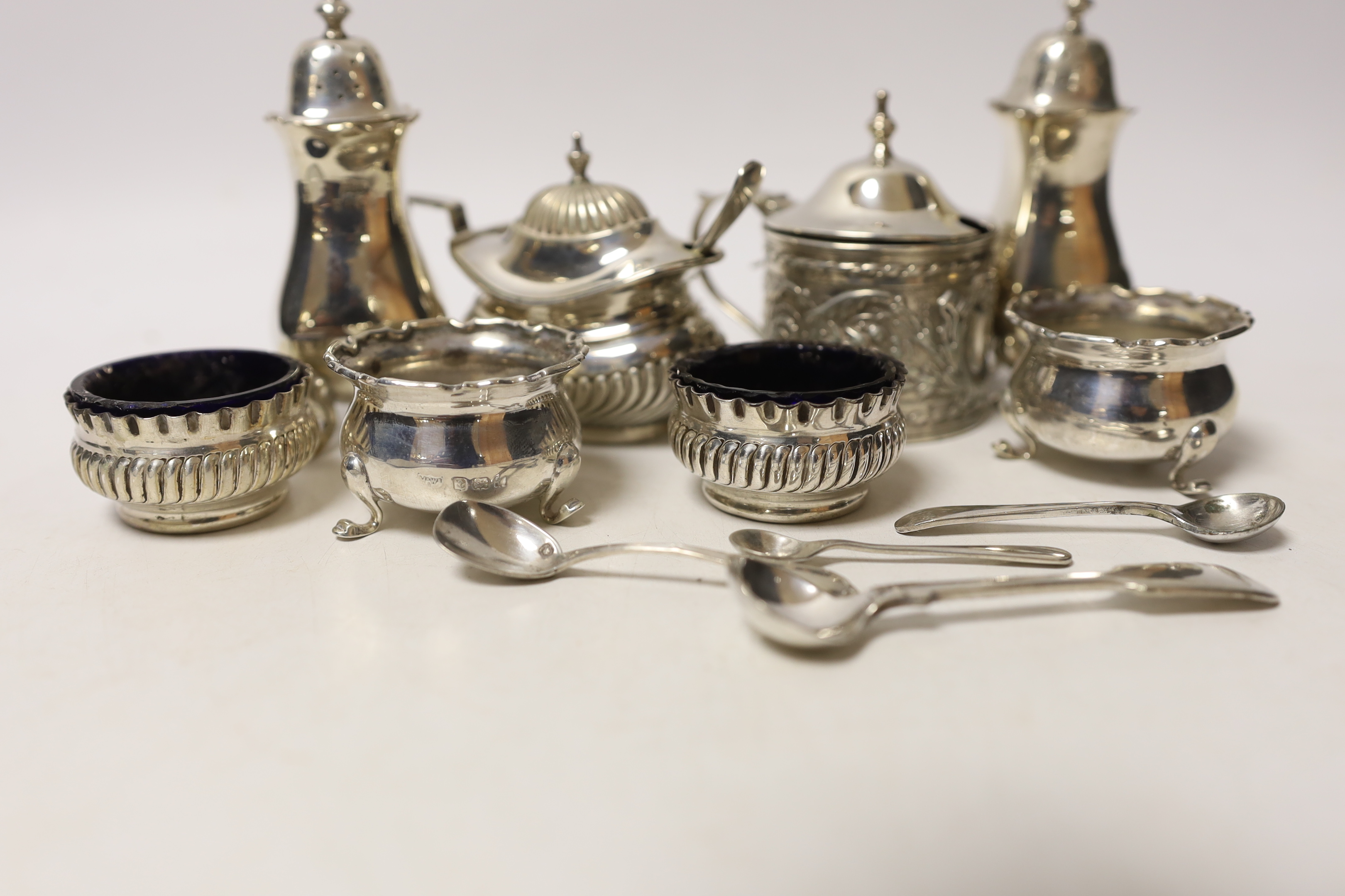 Two pairs of small silver salts, a pair of silver pepperettes, and two silver mustard pots including late Victorian, together with five small spoons (one silver).